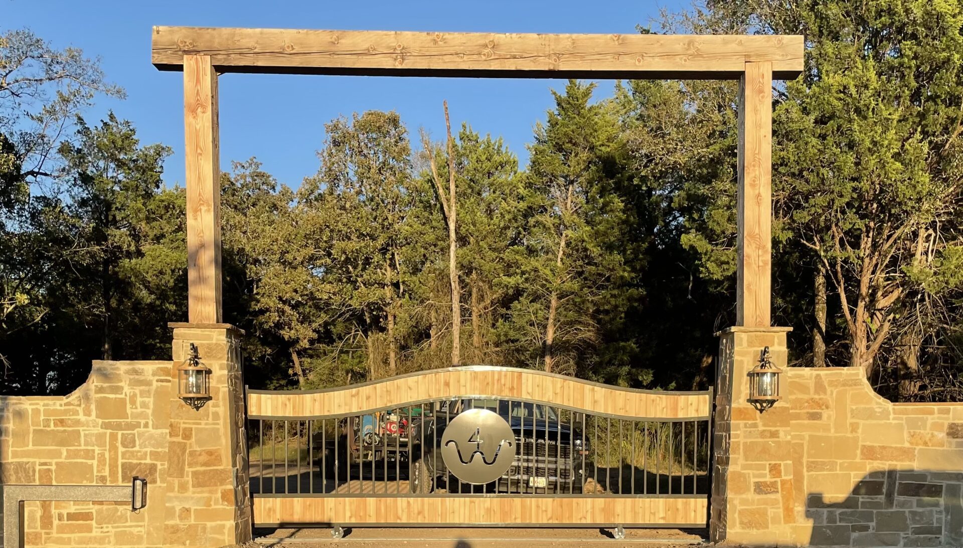 A gate with a sign reading "The Ranch" welcomes visitors to a serene and picturesque countryside retreat.