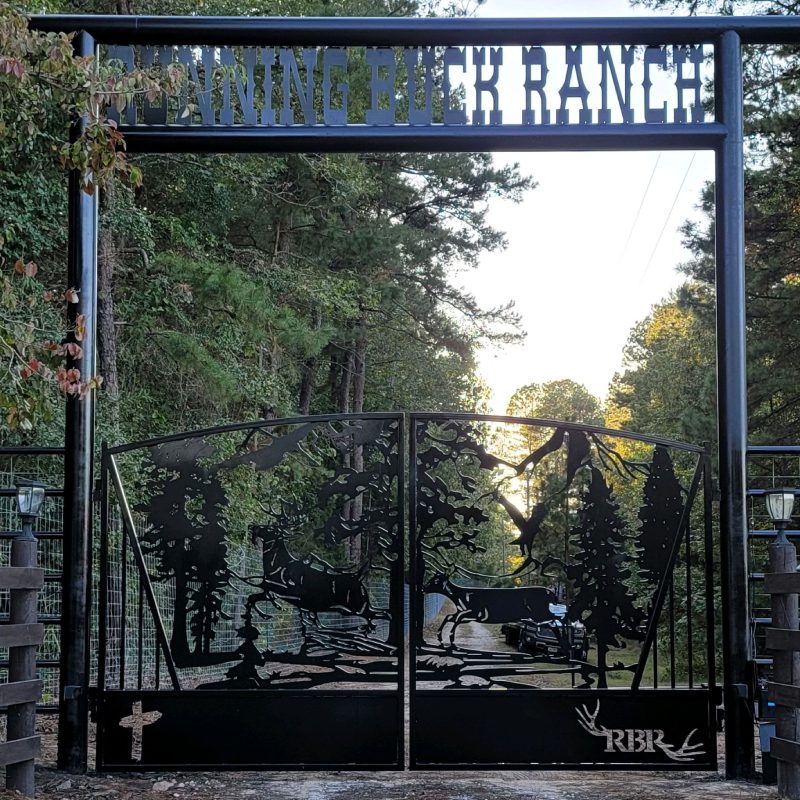 A gate with a sign that reads "The Mountain Ranch" in front of a scenic landscape.